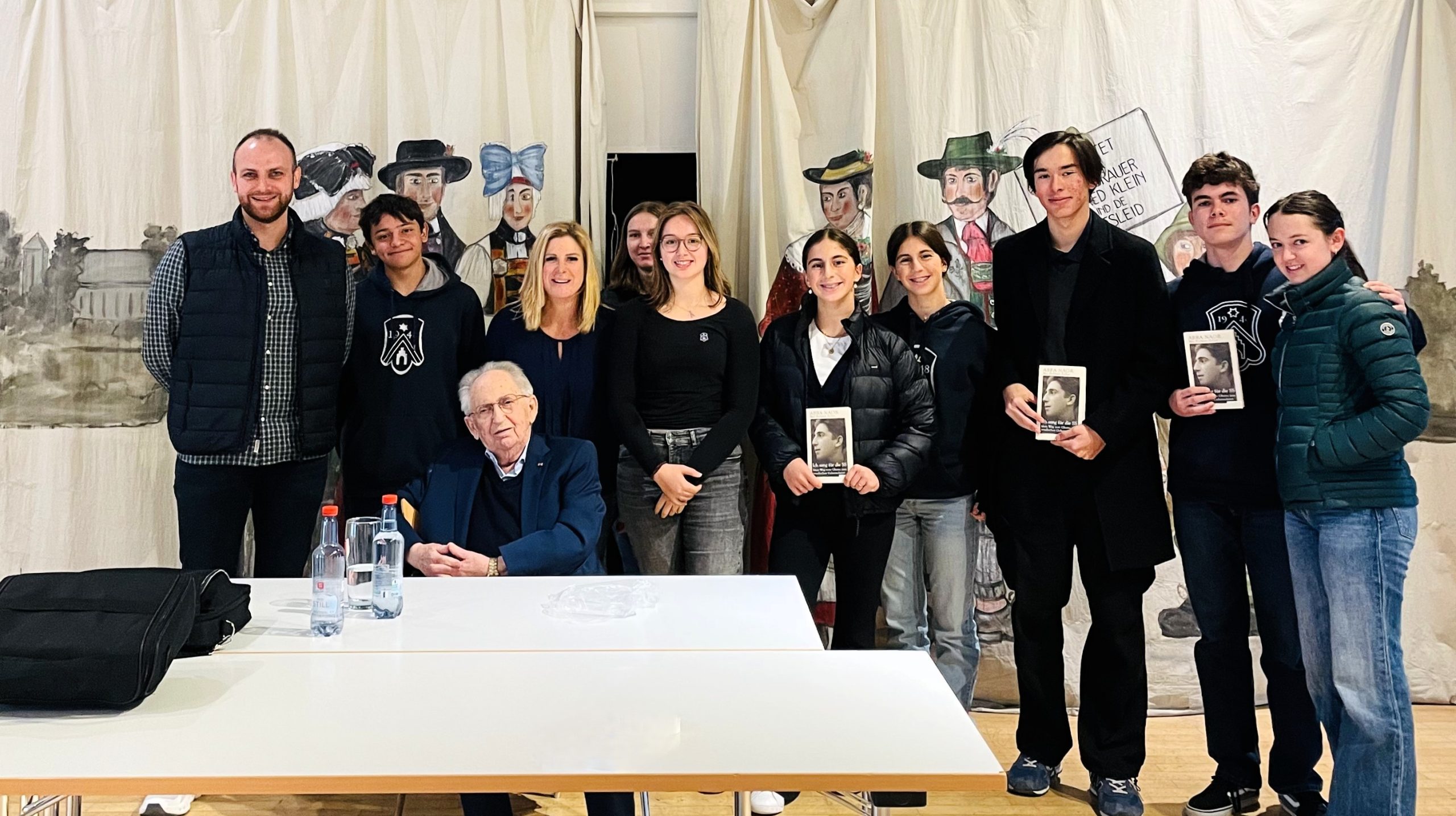 Schülerinnen, Schüler und Lehrkräfte in Dachau mit einem einem Zeitzeugen in Dachau.
